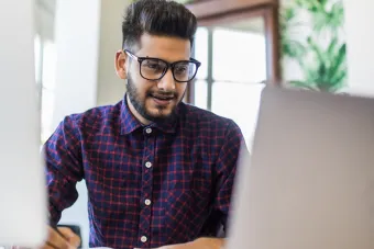 Photo of a male college student working at a laptop